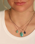 Smooth Asymmetrical Turquoise Pendant Necklace with 18K Bezel Set Cognac Diamond Detail on Brown Cord - Peridot Fine Jewelry - Margaret Solow Jewelry